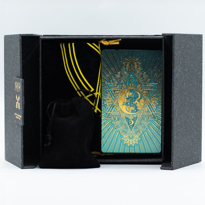 Decorative playing cards with gold and blue design in a black box on a white background